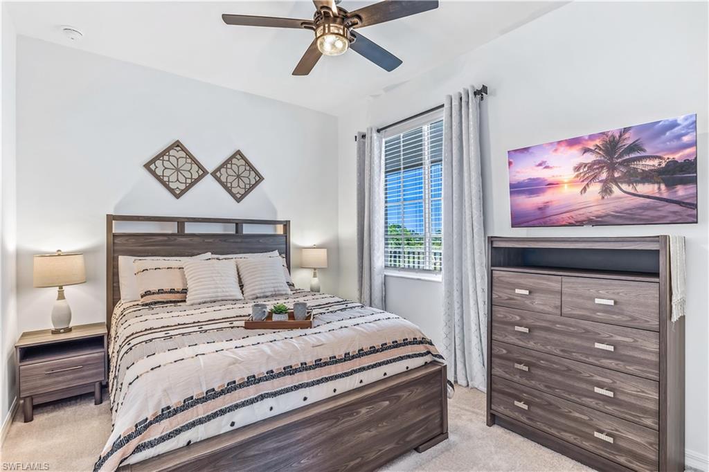 43989 Boardwalk Loop, Unit 2046 Babcock Ranch, FL 33982 - Photo 8 of 12 a bedroom with a bed and a chandelier