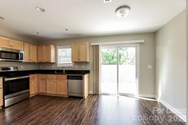 a kitchen with granite countertop a stove a sink and a microwave