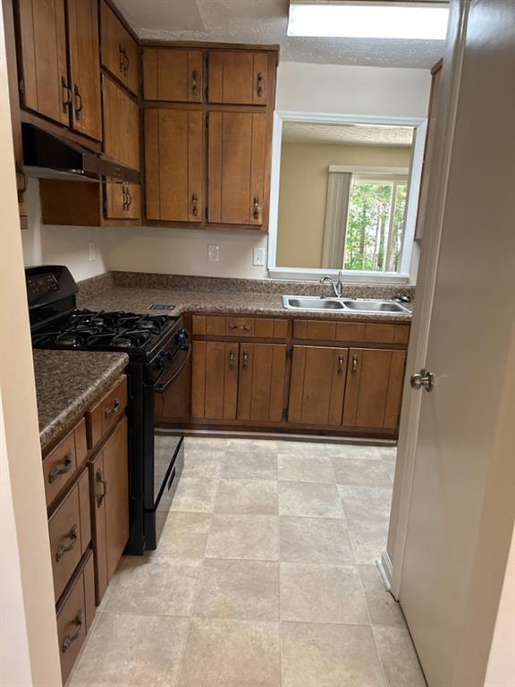 5956 North Castlegate Drive Atlanta, GA 30349 - Photo 6 of 28 a kitchen with stainless steel appliances granite countertop a stove a sink and a refrigerator