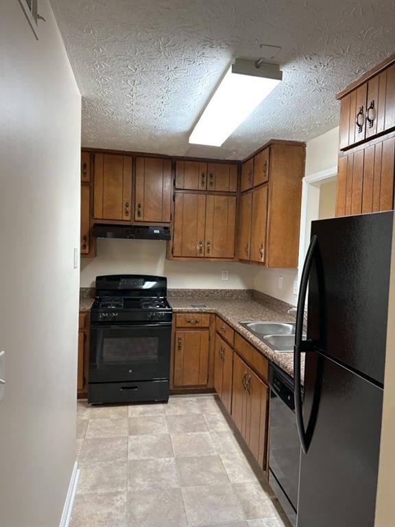 5956 North Castlegate Drive Atlanta, GA 30349 - Photo 7 of 28 a kitchen with stainless steel appliances granite countertop a refrigerator stove top oven a sink and dishwasher