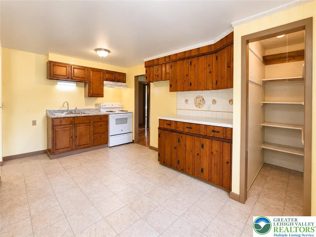 4995 Mountain Road Slatington, PA 18080 - Photo 11 of 30 Warm wood cabinetry and durable tile flooring define this spacious kitchen, complete with a walk-in pantry.