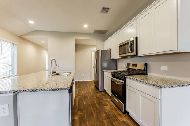 a kitchen with stainless steel appliances granite countertop a sink stove and refrigerator