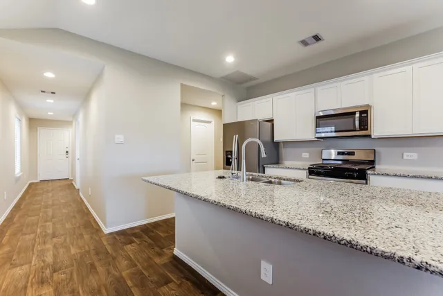 a kitchen with sink a refrigerator and microwave
