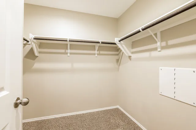 a view of walk in closet with empty racks