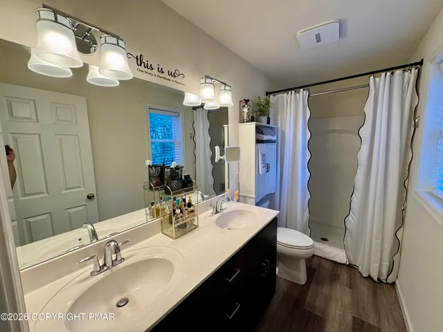 a bathroom with a double vanity sink mirror and shower