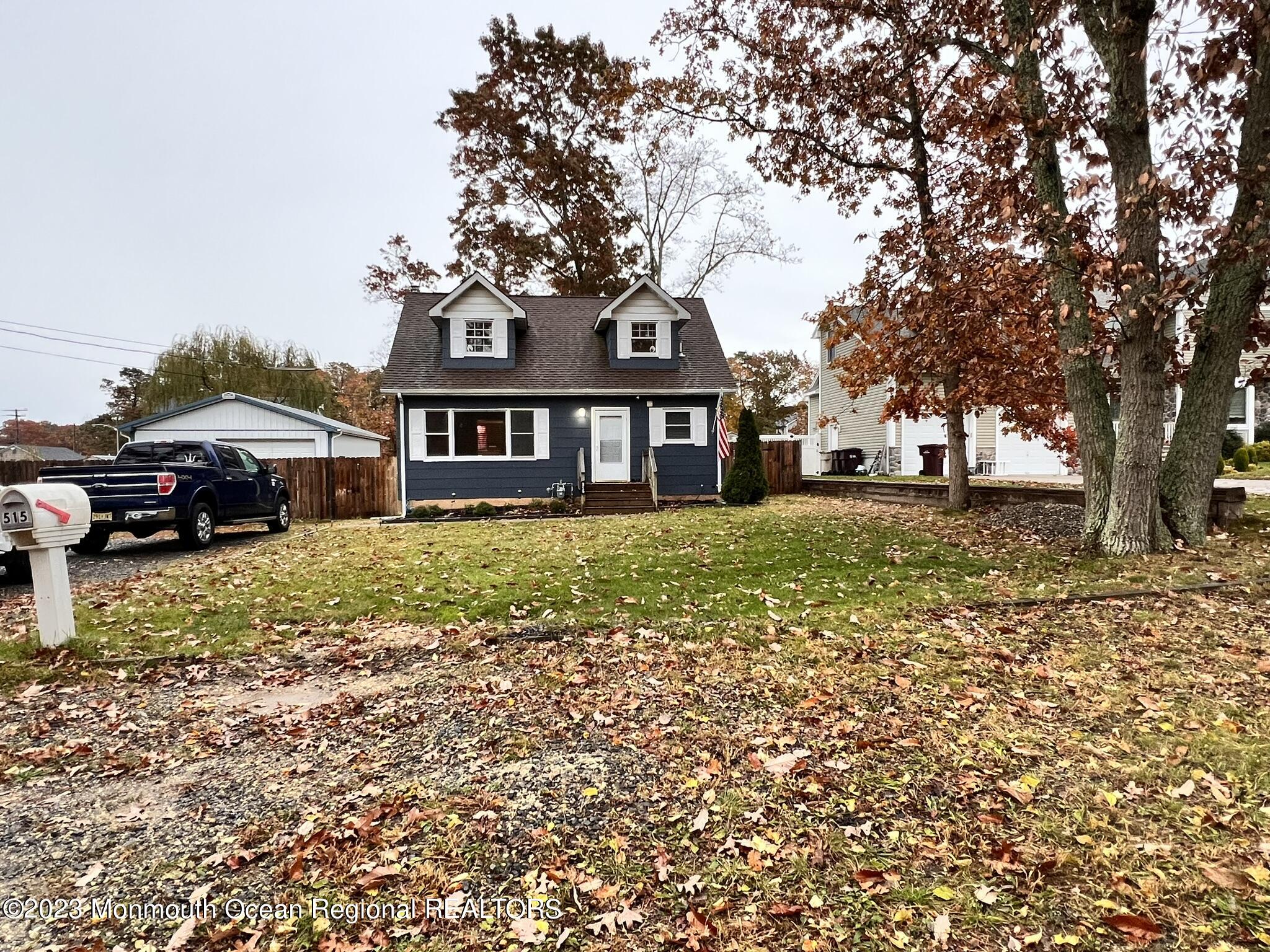 a front view of a house with a garden and trees