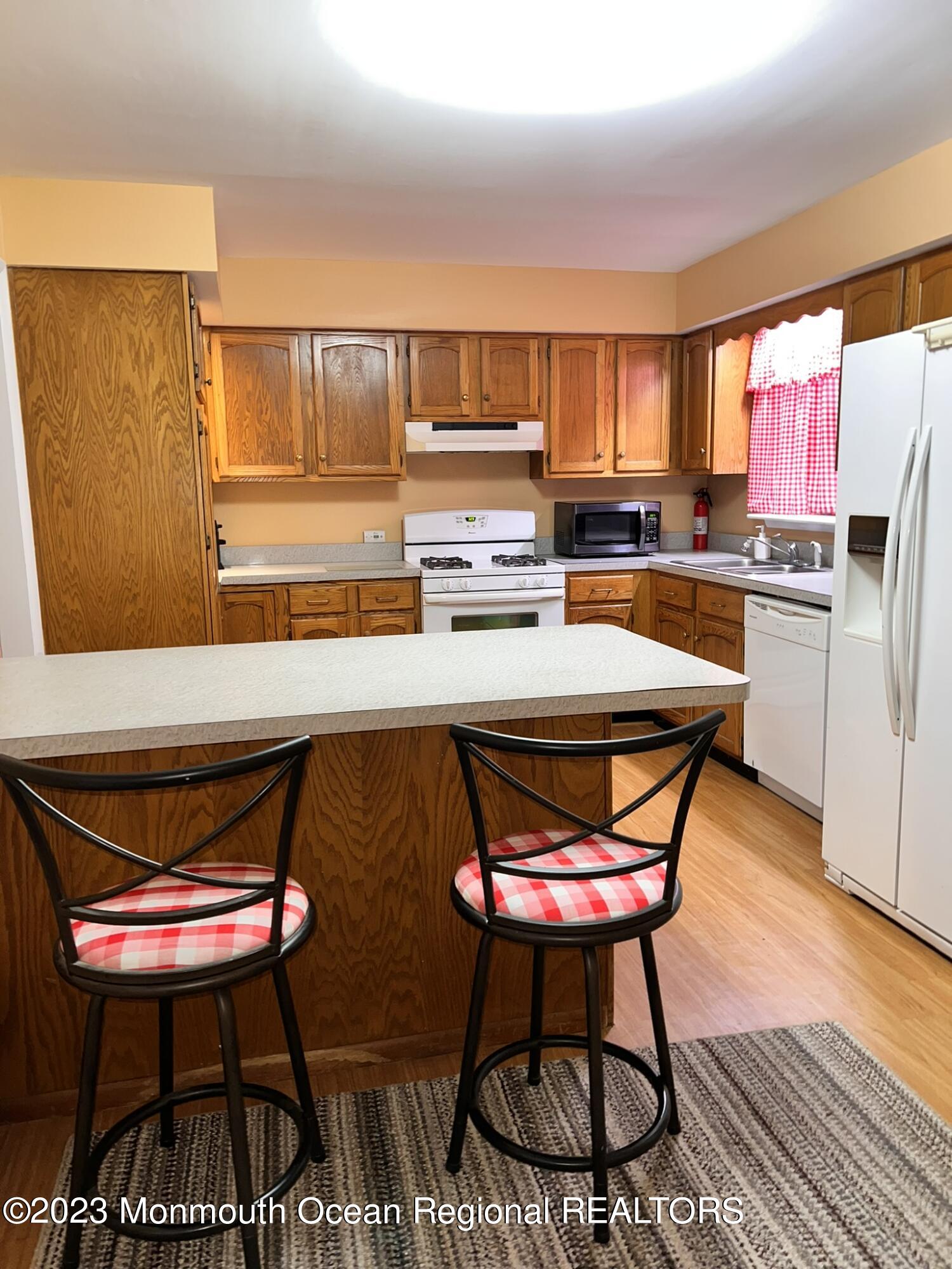 515 Eastern Boulevard Bayville, NJ 08721 - Photo 8 of 38 a kitchen with a stove and chairs