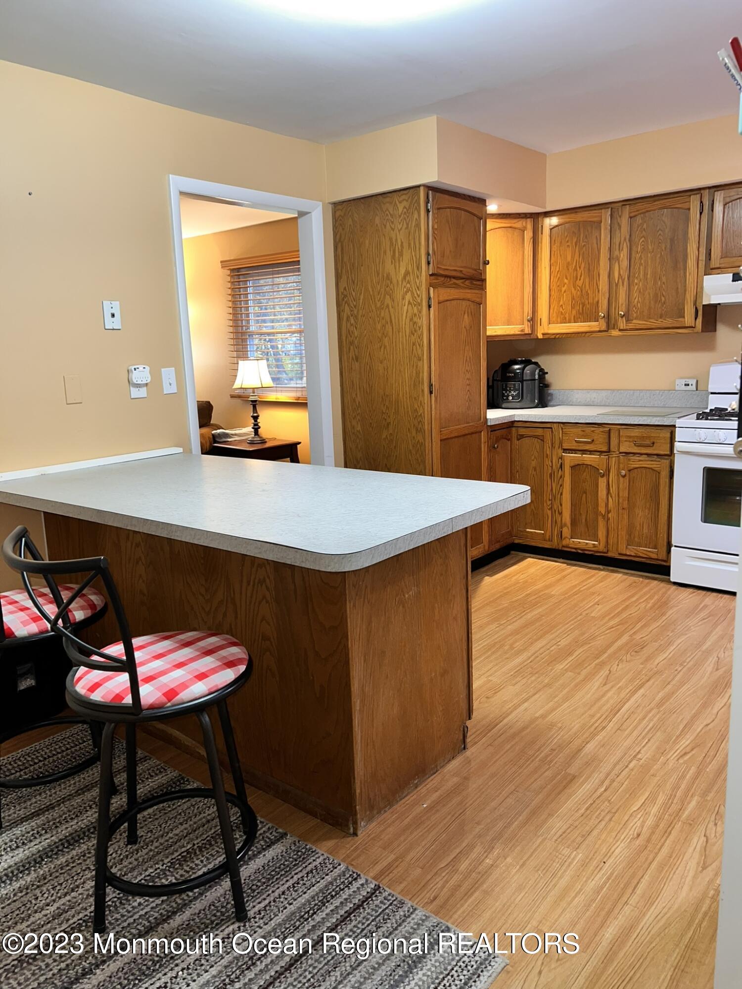 515 Eastern Boulevard Bayville, NJ 08721 - Photo 10 of 38 a kitchen with stainless steel appliances wooden floor and a refrigerator