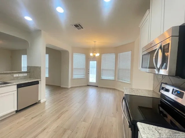a kitchen with stainless steel appliances granite countertop a stove and a wooden floors