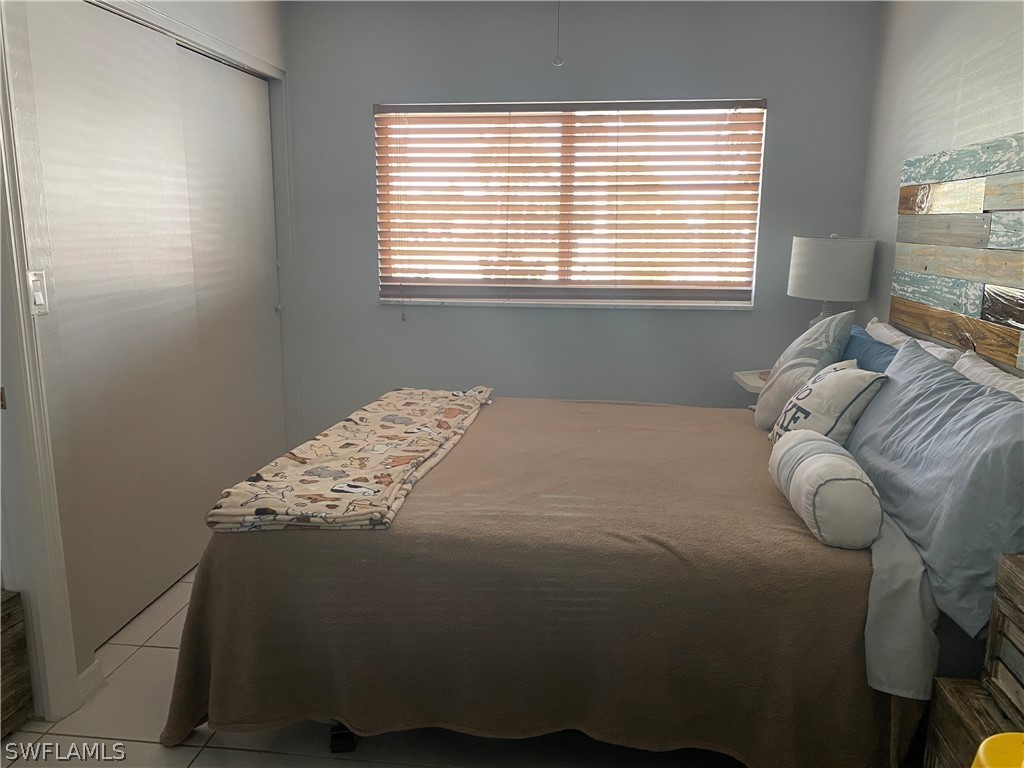 3211 Stringfellow Road, Unit 1D St. James City, FL 33956 - Photo 12 of 22 a bed sitting in a bedroom next to a window