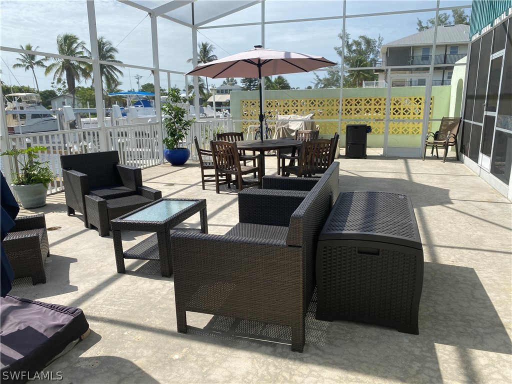 3211 Stringfellow Road, Unit 1D St. James City, FL 33956 - Photo 18 of 22 a view of a patio with a dining table and chairs