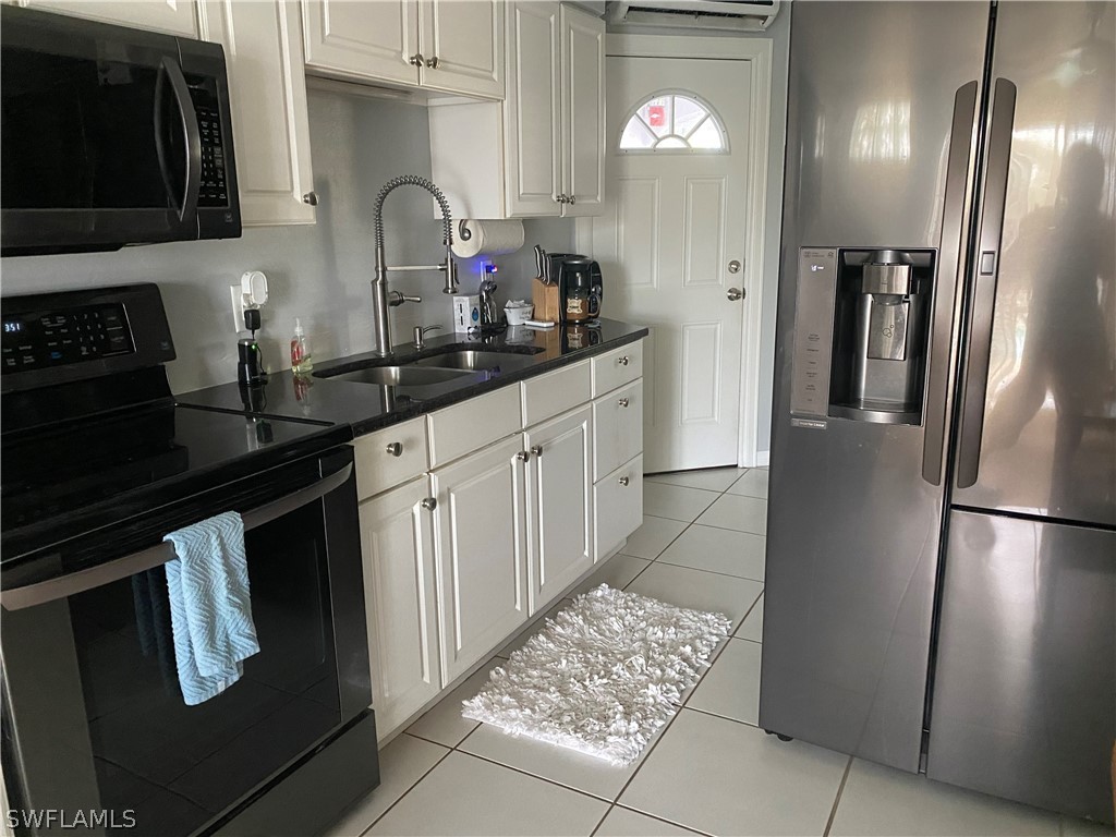 3211 Stringfellow Road, Unit 1D St. James City, FL 33956 - Photo 3 of 22 a kitchen with stainless steel appliances granite countertop a refrigerator and a stove