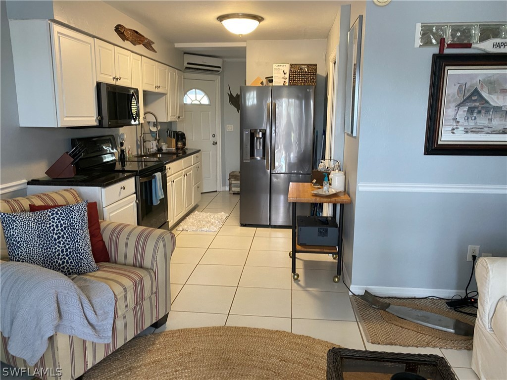 3211 Stringfellow Road, Unit 1D St. James City, FL 33956 - Photo 9 of 22 a kitchen with stainless steel appliances kitchen island granite countertop a refrigerator and a stove top oven