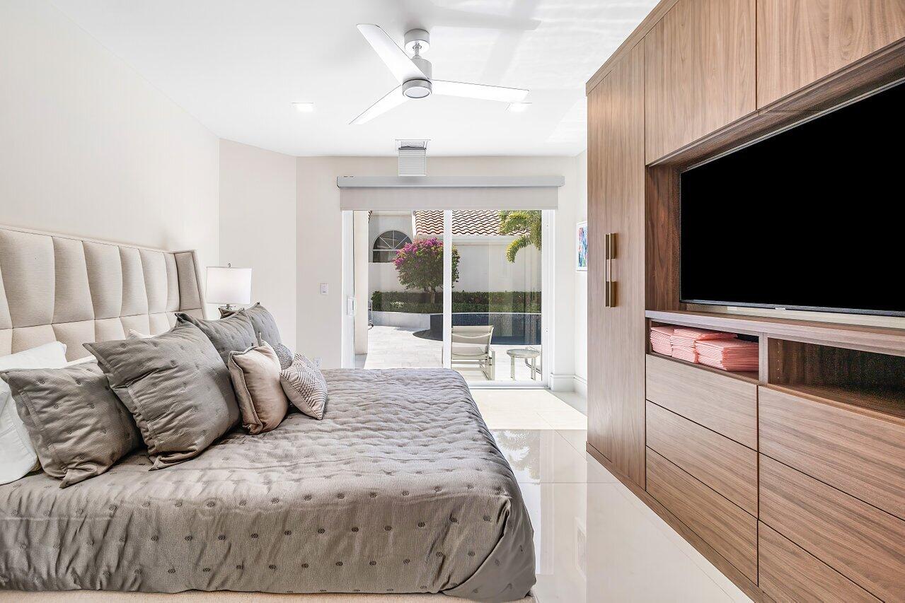 3506 Northwest Clubside Circle Boca Raton, FL 33496 - Photo 14 of 46 a spacious bedroom with a bed and a flat screen tv