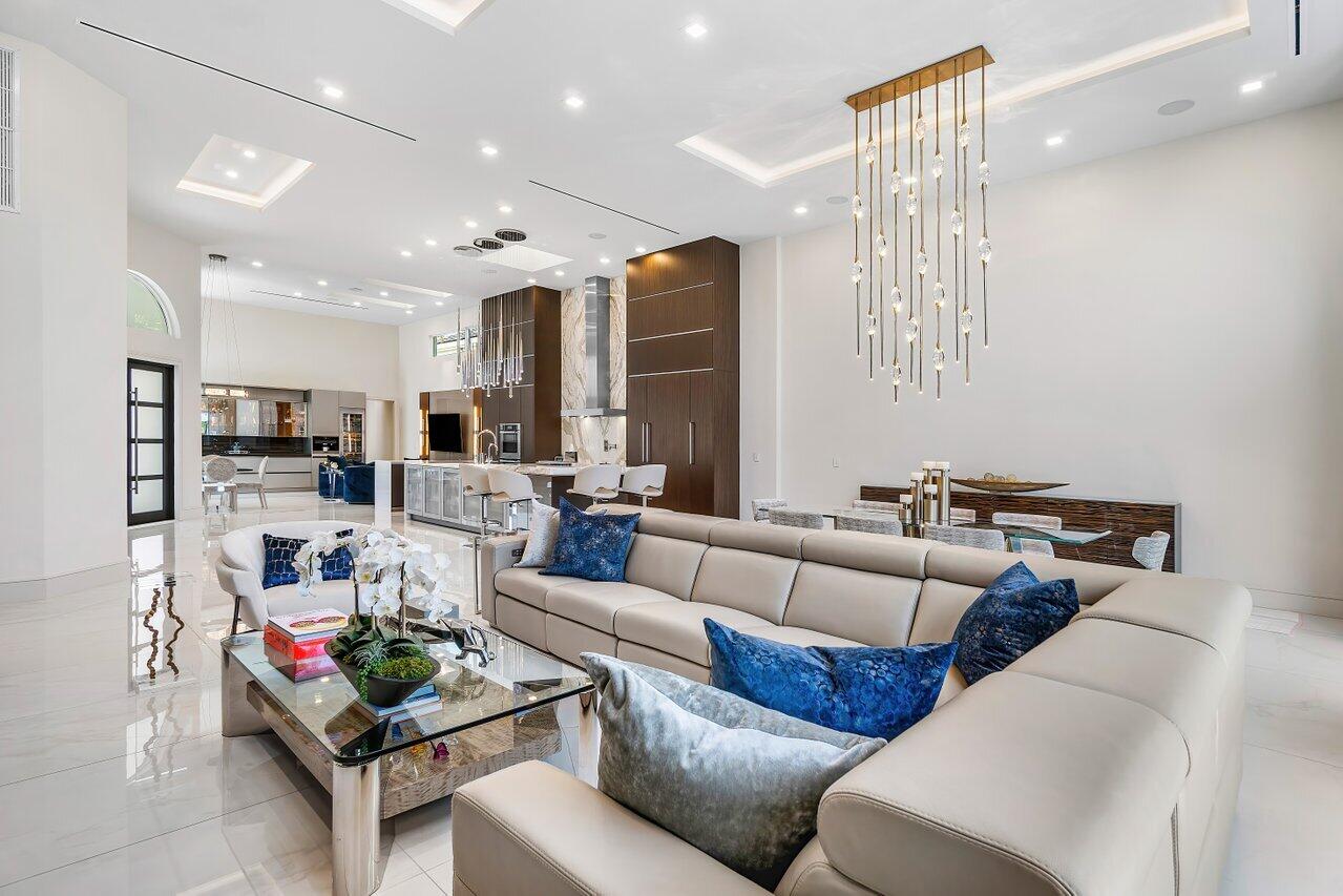 3506 Northwest Clubside Circle Boca Raton, FL 33496 - Photo 9 of 46 a living room with furniture kitchen view and a chandelier