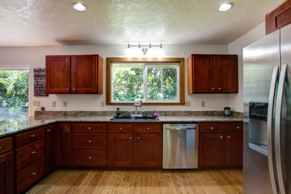 6490 Kipapa Road, Unit B Kapaa, HI 96746 - Photo 3 of 24 a kitchen with stainless steel appliances granite countertop a stove a sink dishwasher and a refrigerator