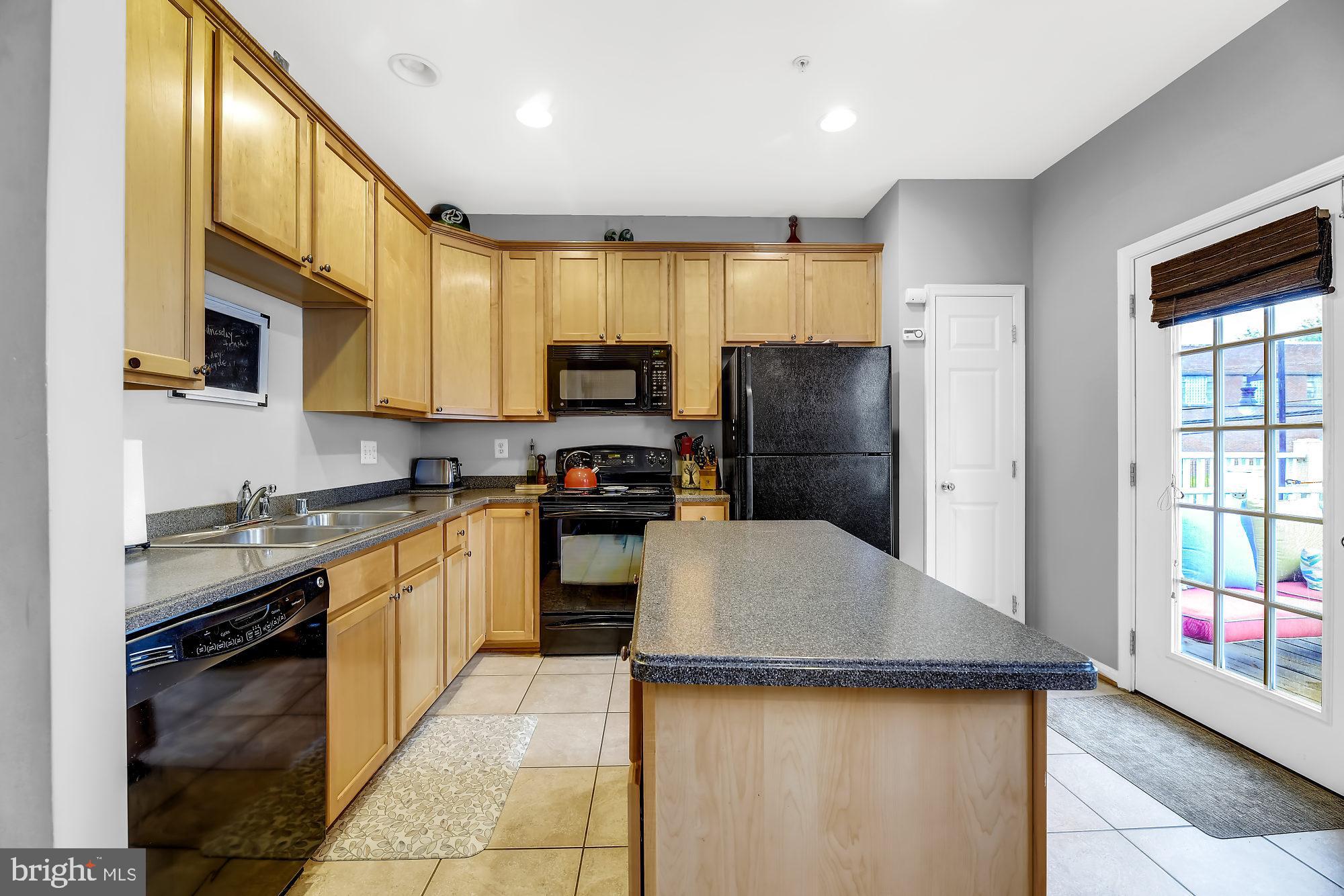 2090 Clipper Park Road Baltimore, MD 21211 - Photo 7 of 75 a kitchen with a sink a microwave a refrigerator and cabinets
