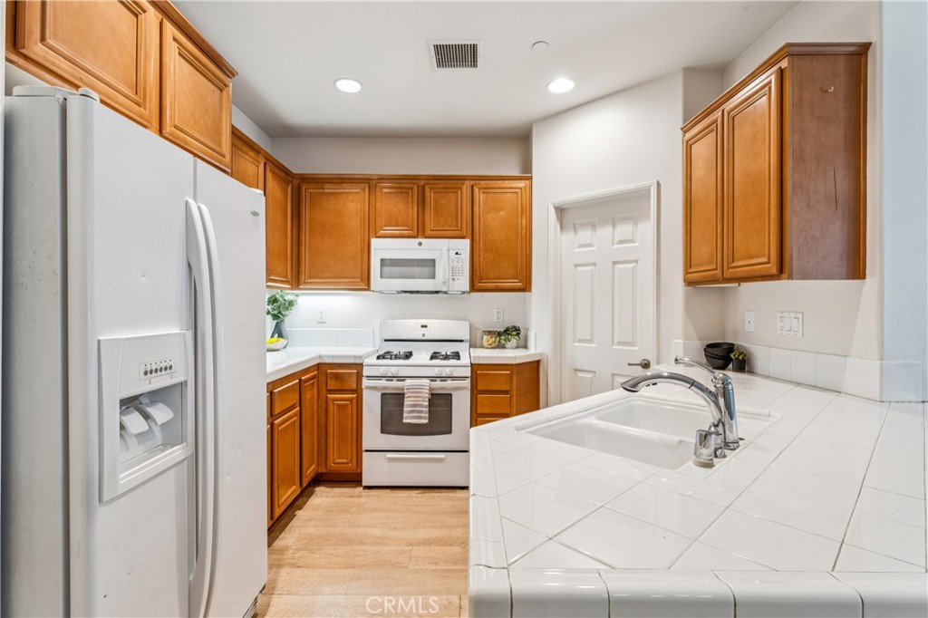 8048 Tulsa Place, Unit 105 Rancho Cucamonga, CA 91730 - Photo 12 of 45 a kitchen with stainless steel appliances granite countertop a refrigerator sink and stove
