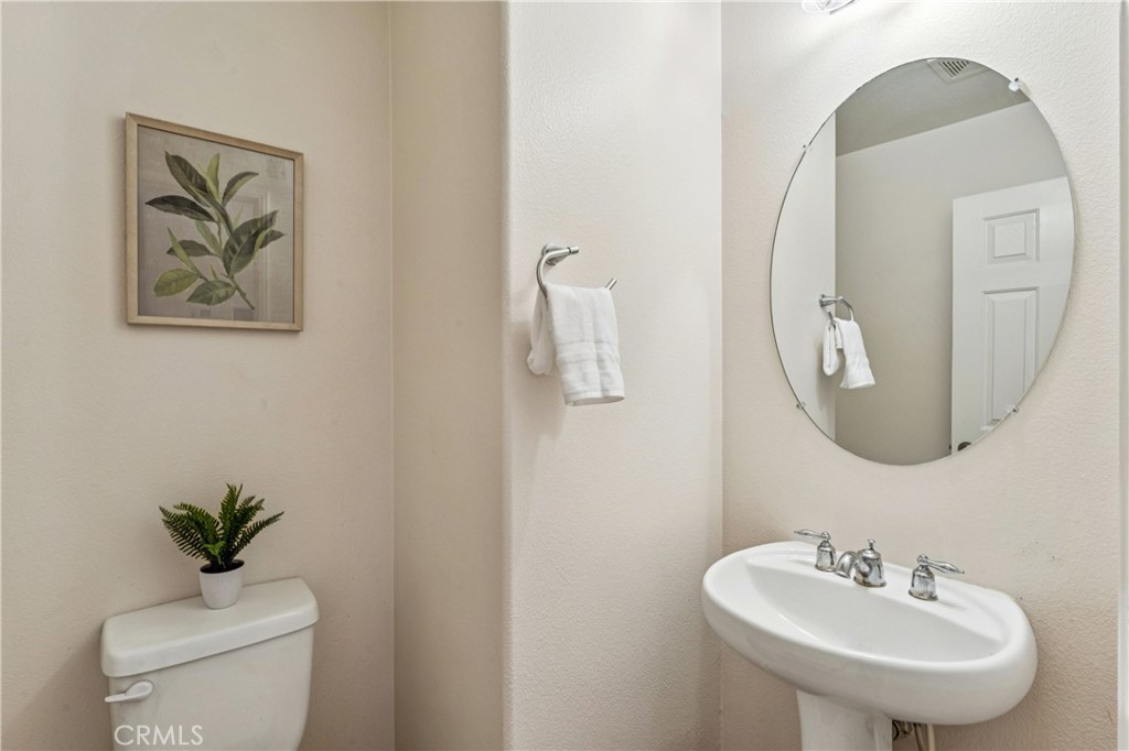 8048 Tulsa Place, Unit 105 Rancho Cucamonga, CA 91730 - Photo 15 of 45 a bathroom with a toilet a sink and mirror