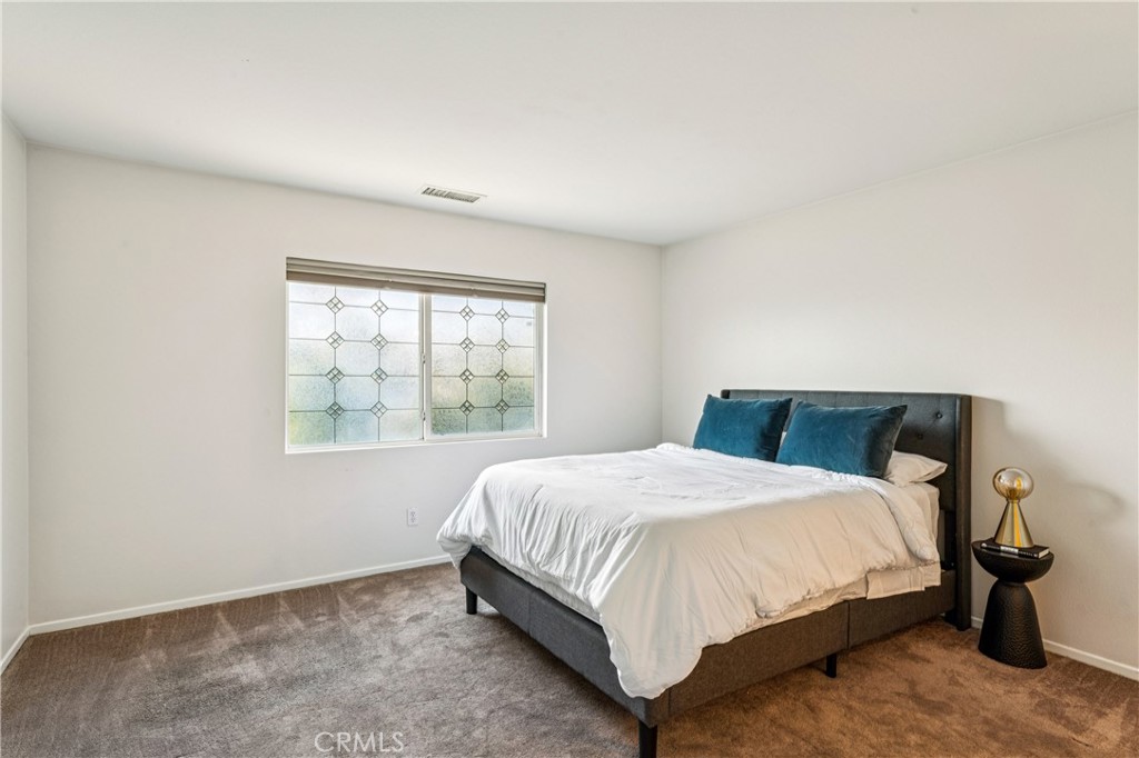 8048 Tulsa Place, Unit 105 Rancho Cucamonga, CA 91730 - Photo 19 of 45 a large bed sitting in a bedroom next to a window