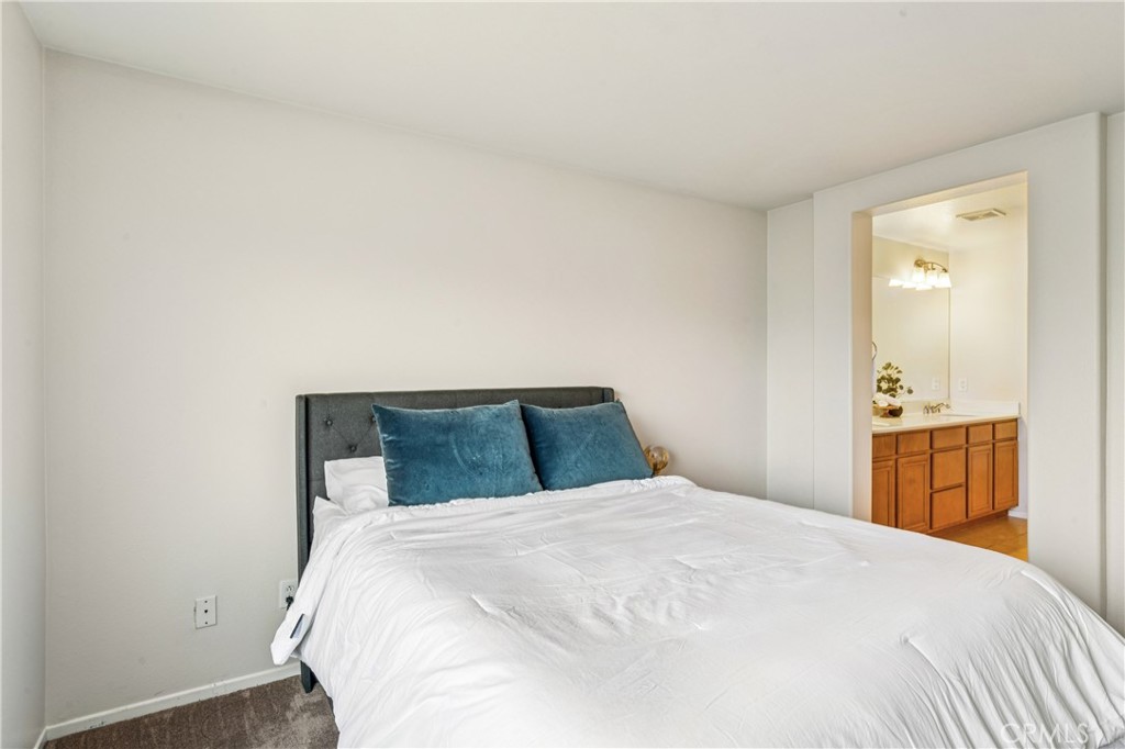 8048 Tulsa Place, Unit 105 Rancho Cucamonga, CA 91730 - Photo 20 of 45 a bedroom with a large bed and wooden floor