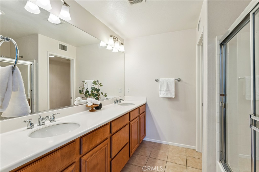 8048 Tulsa Place, Unit 105 Rancho Cucamonga, CA 91730 - Photo 21 of 45 a bathroom with a double vanity sink and a mirror