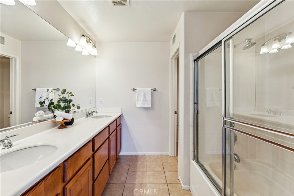 8048 Tulsa Place, Unit 105 Rancho Cucamonga, CA 91730 - Photo 22 of 45 a bathroom with a sink a mirror and a shower
