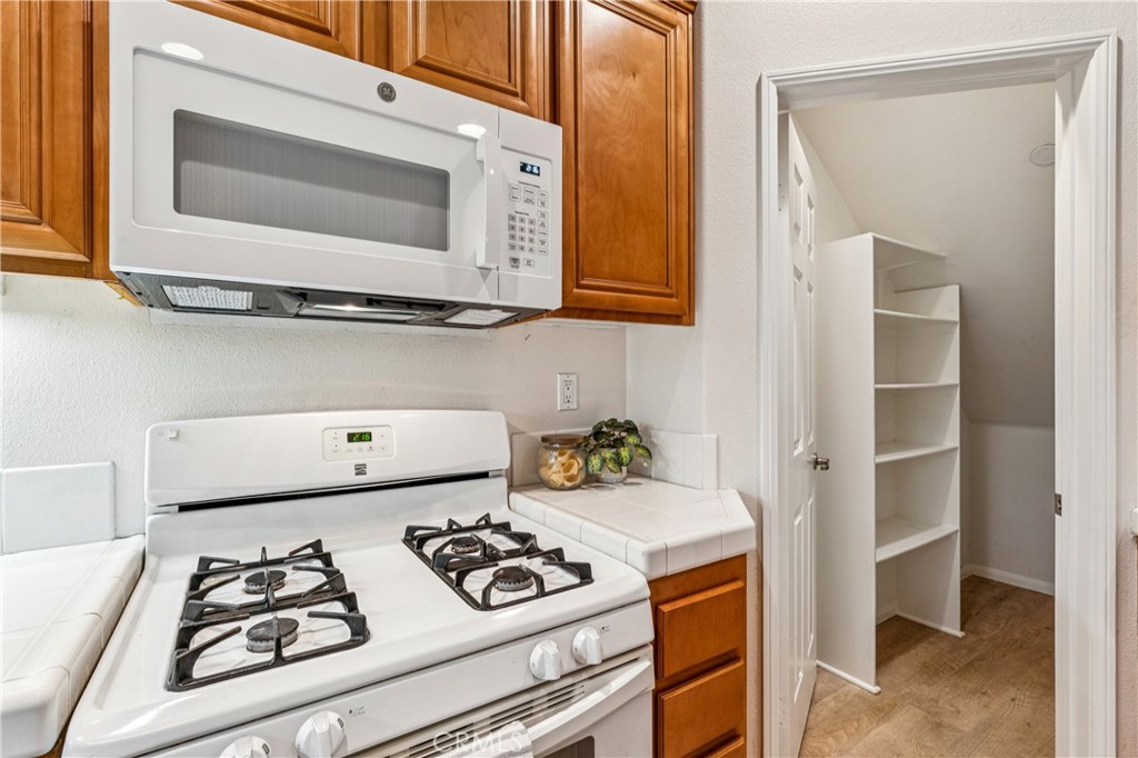 8048 Tulsa Place, Unit 105 Rancho Cucamonga, CA 91730 - Photo 31 of 45 a kitchen with stove and white cabinets
