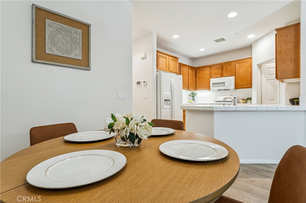 8048 Tulsa Place, Unit 105 Rancho Cucamonga, CA 91730 - Photo 10 of 45 a kitchen with stainless steel appliances a dining table and chairs