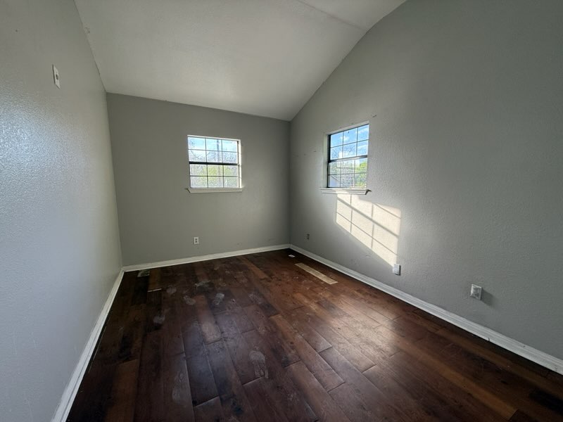 5609 Gloucester Lane Austin, TX 78723 - Photo 4 of 7 an empty room with wooden floor and windows