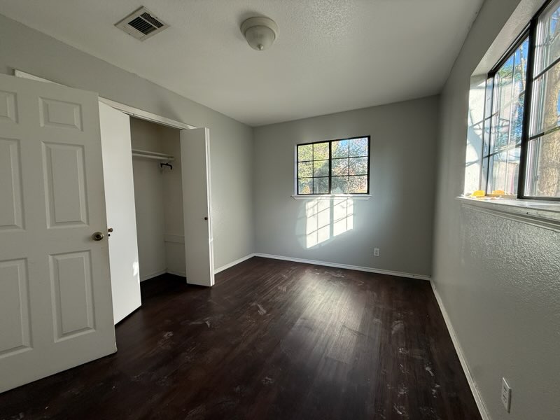 5609 Gloucester Lane Austin, TX 78723 - Photo 6 of 7 an empty room with wooden floor and windows
