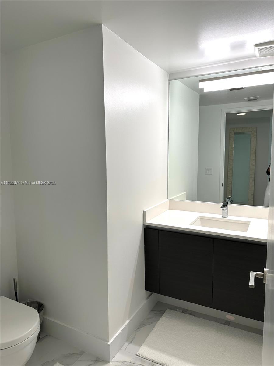 330 Sunny Isles Boulevard, Unit 52002 Sunny Isles Beach, FL 33160 - Photo 13 of 56 a bathroom with a sink and a mirror