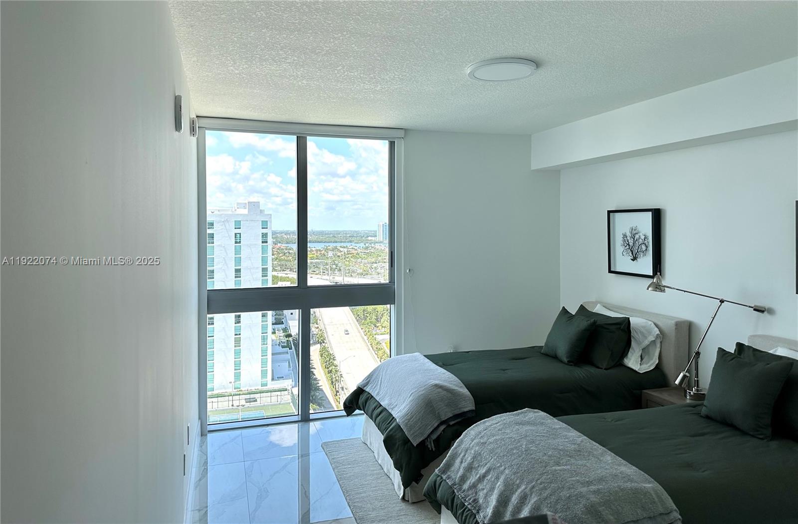 330 Sunny Isles Boulevard, Unit 52002 Sunny Isles Beach, FL 33160 - Photo 15 of 56 a bedroom with a bed and a large window