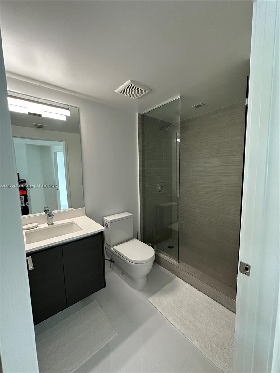 330 Sunny Isles Boulevard, Unit 52002 Sunny Isles Beach, FL 33160 - Photo 18 of 56 a bathroom with a sink toilet a mirror and shower