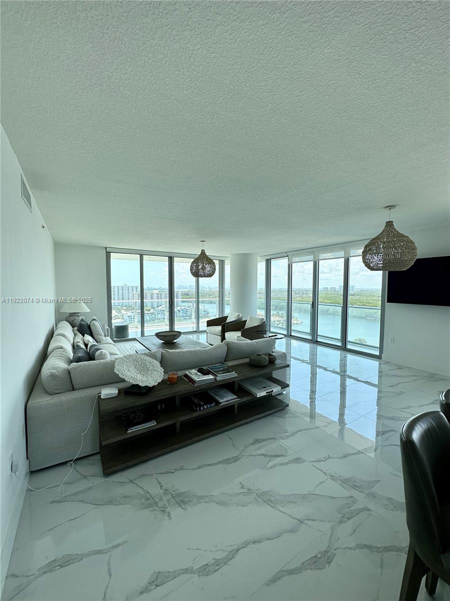 330 Sunny Isles Boulevard, Unit 52002 Sunny Isles Beach, FL 33160 - Photo 21 of 56 a living room with furniture and a floor to ceiling window