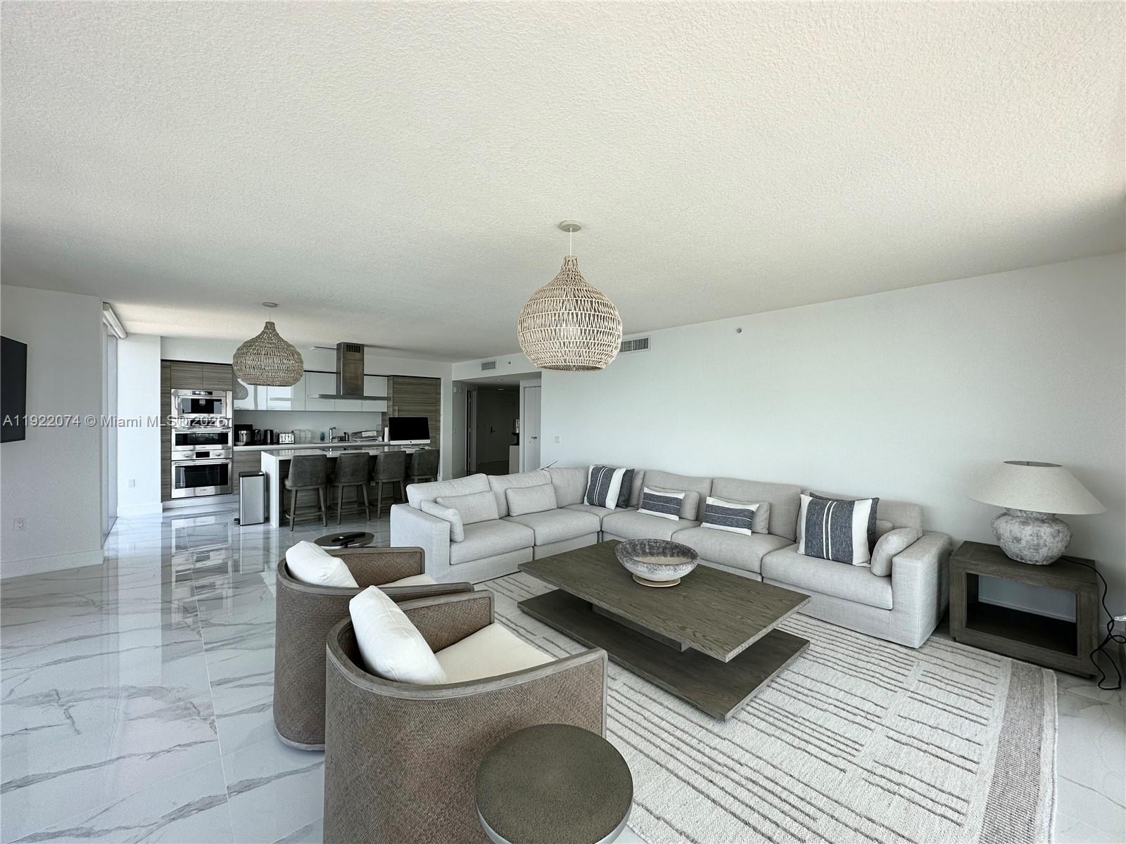 330 Sunny Isles Boulevard, Unit 52002 Sunny Isles Beach, FL 33160 - Photo 22 of 56 a living room with furniture a rug and kitchen view