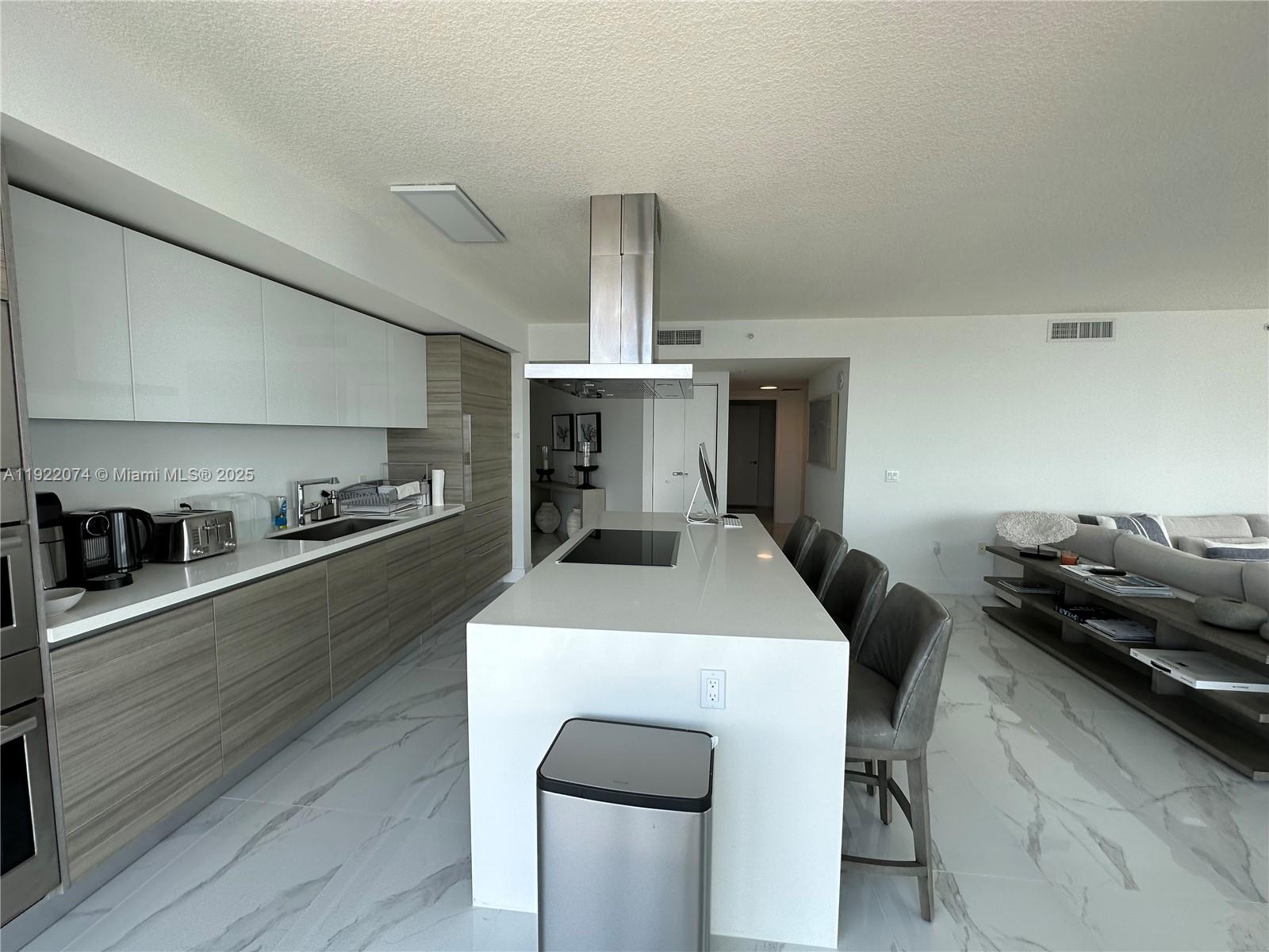 330 Sunny Isles Boulevard, Unit 52002 Sunny Isles Beach, FL 33160 - Photo 33 of 56 a kitchen with a table and chairs