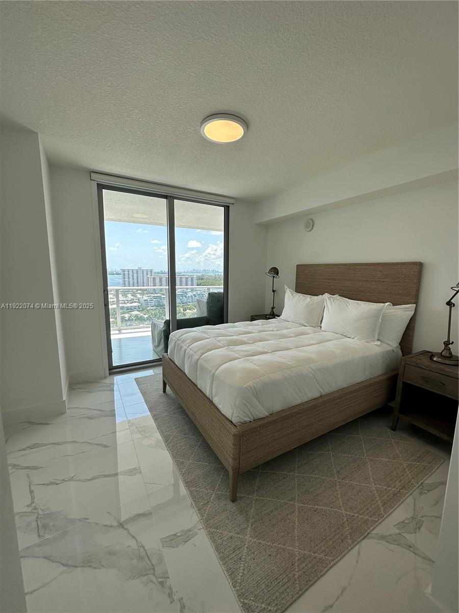 330 Sunny Isles Boulevard, Unit 52002 Sunny Isles Beach, FL 33160 - Photo 39 of 56 a bedroom with a bed and a window