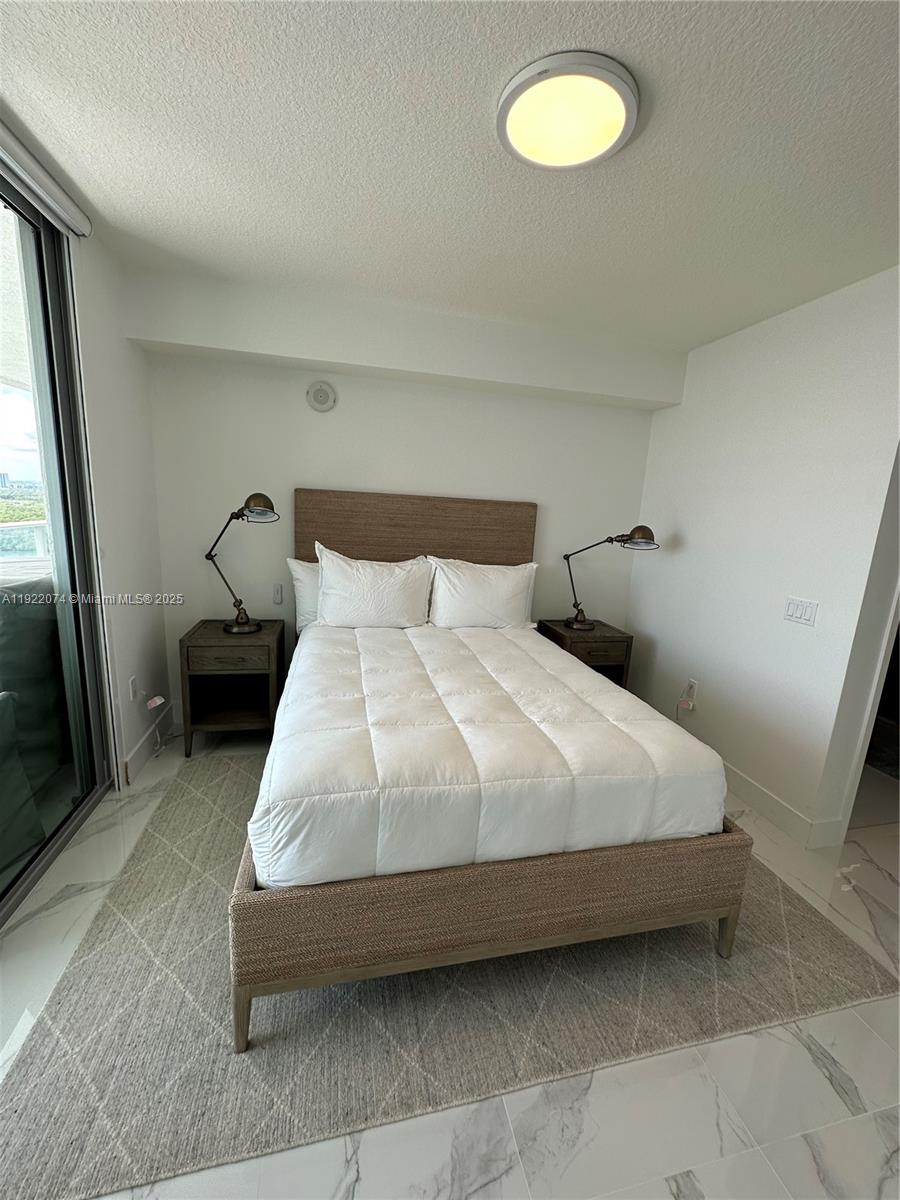 330 Sunny Isles Boulevard, Unit 52002 Sunny Isles Beach, FL 33160 - Photo 40 of 56 a bedroom with a bed and a window