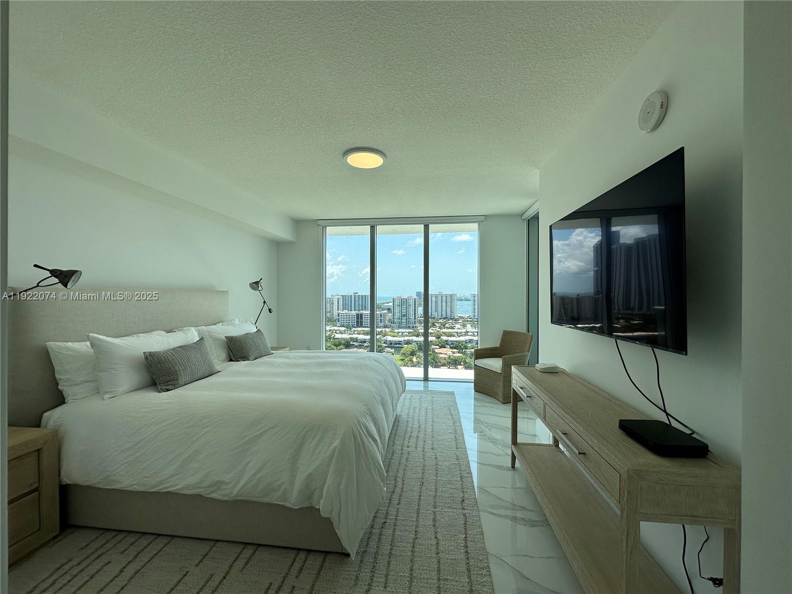 330 Sunny Isles Boulevard, Unit 52002 Sunny Isles Beach, FL 33160 - Photo 44 of 56 a bedroom with a bed and a flat screen tv