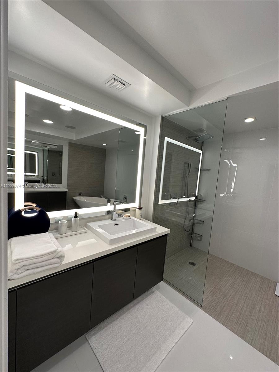330 Sunny Isles Boulevard, Unit 52002 Sunny Isles Beach, FL 33160 - Photo 53 of 56 a bathroom with a sink double vanity and a mirror