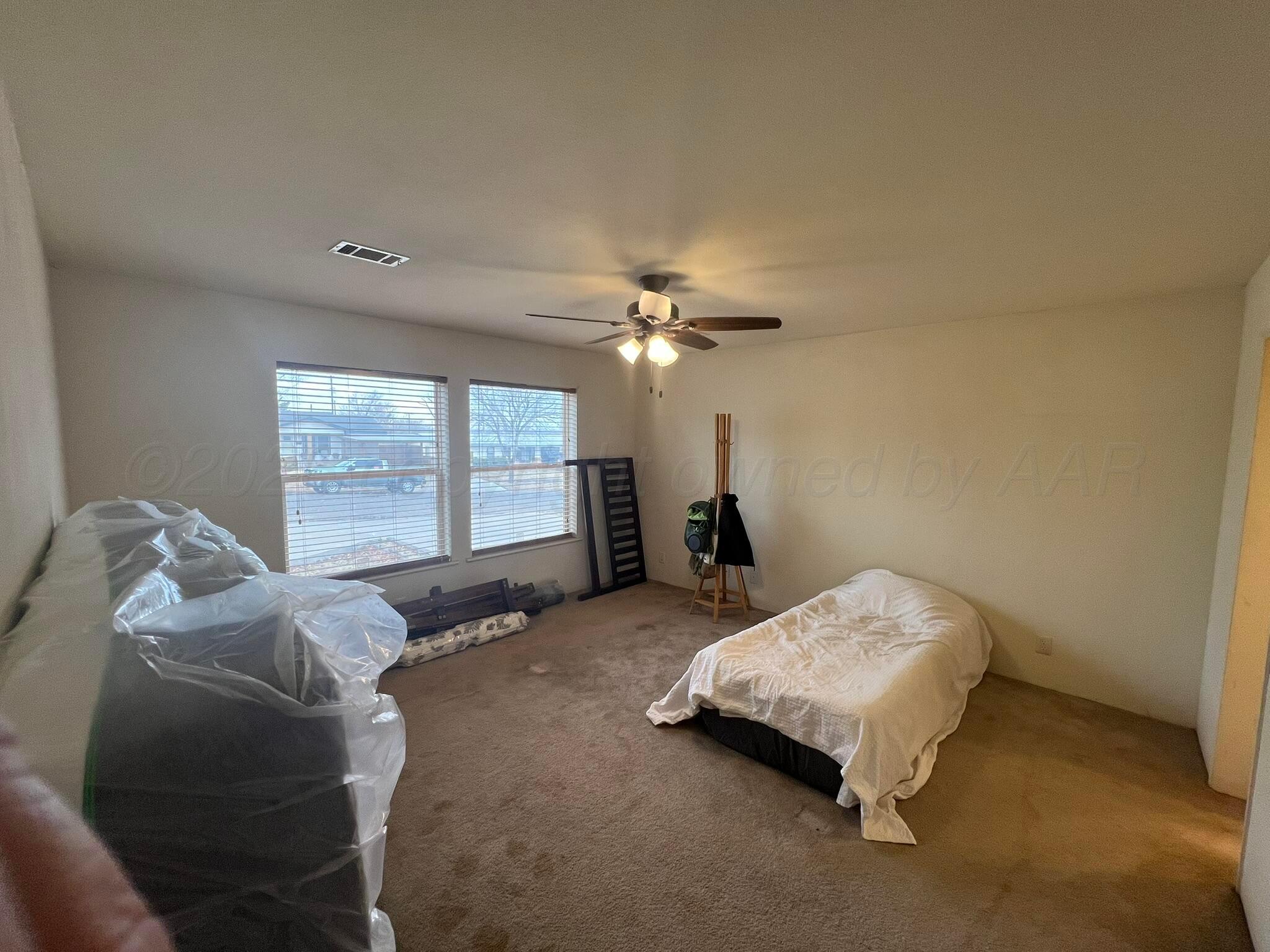 707 Conklin Street Canadian, TX 79014 - Photo 17 of 38 a bed room with a bed and a chandelier