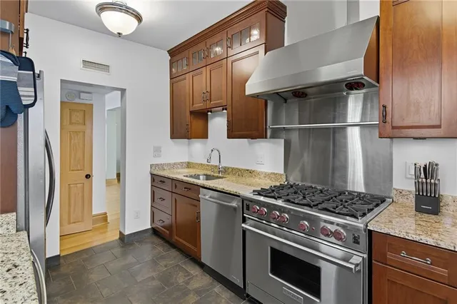 a kitchen with stainless steel appliances granite countertop a sink stove and refrigerator