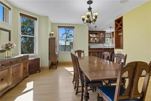 a view of a dining room with furniture a chandelier and wooden floor