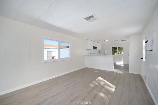 a view of a kitchen with wooden floor and a kitchen space