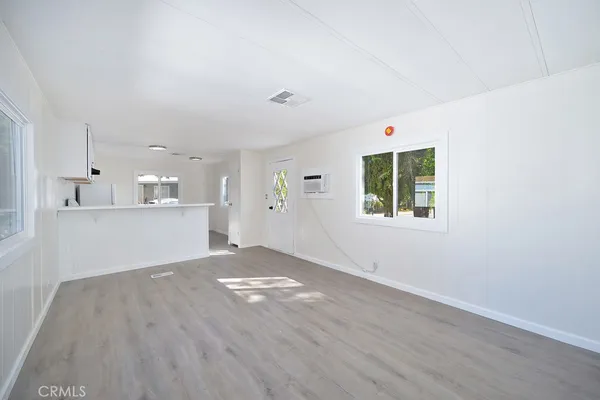 a view of a kitchen with wooden floor and windows
