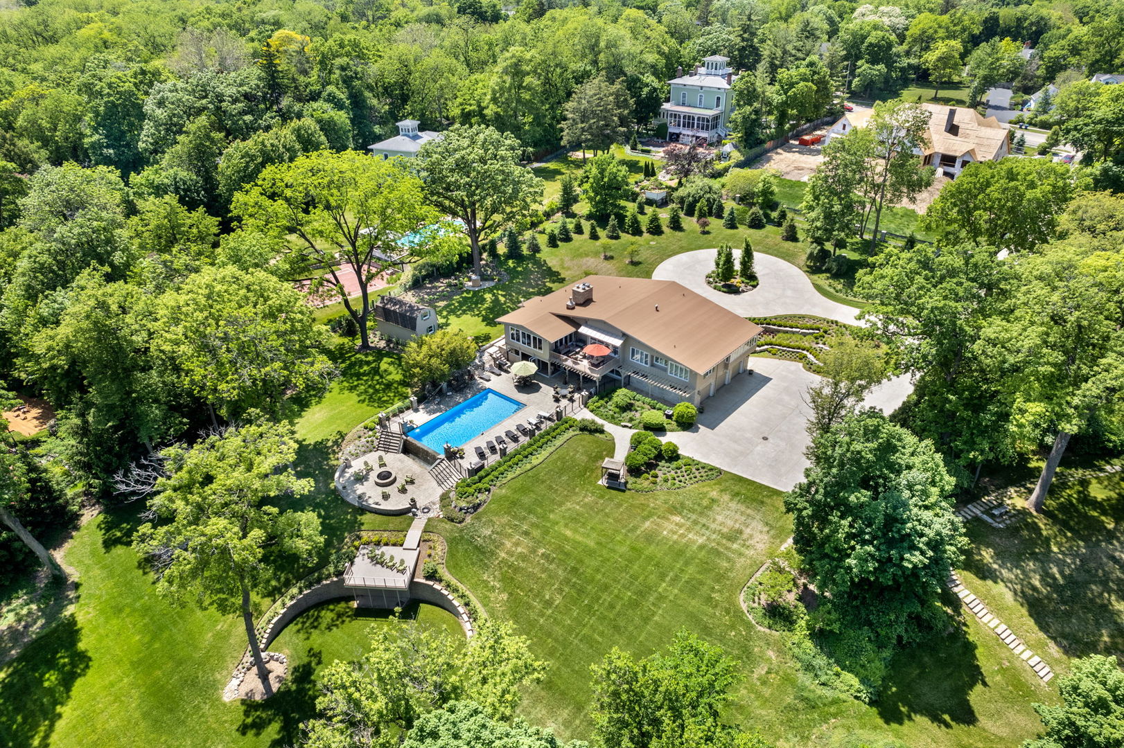 an aerial view of a house with swimming pool and garden