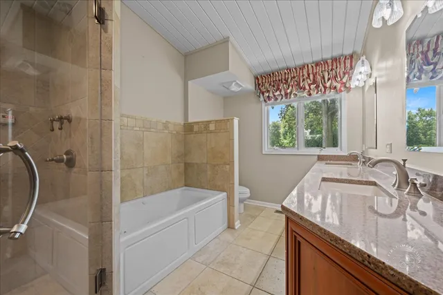 a bathroom with a granite countertop sink a mirror and a bathtub