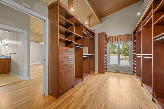 a view of walk in closet with wooden floor