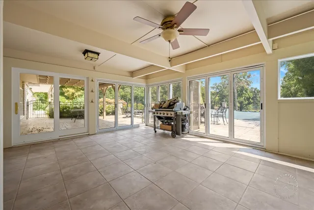 a view of an empty room with furniture and a large window